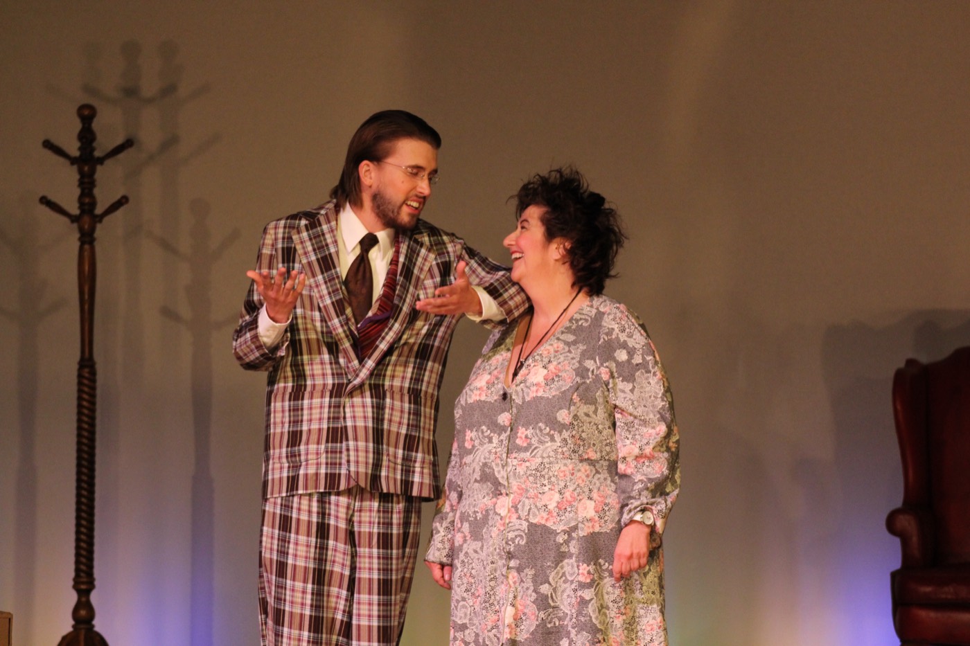 Two actors sharing a comic moment on stage.