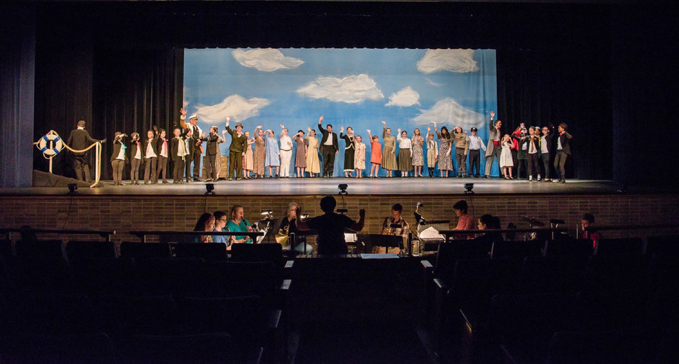Full cast and pit orchestra during a curtain call at the St. Anthony Village High School auditorium.